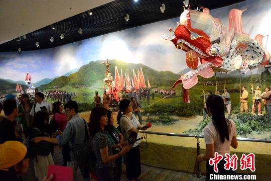 圖為兩岸記者、青年學(xué)生在龍巖市博物館了解閩西客家民俗活動。　張金川　攝