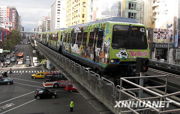 這是行駛在臺北街頭的“熊貓列車”（1月31日攝）。大熊貓“團團”“圓圓”1月26日農歷大年初一在臺北市立動物園公開亮相后，臺灣民眾爭睹大熊貓的風采。為了方便民眾，臺北捷運通往動物園的線路開通了熊貓彩繪列車，車廂上畫上了“團團”“圓圓”從出生、成長、到移居臺北動物園新家的全過程，列車每20分鐘發出一班。新華社記者王妍攝