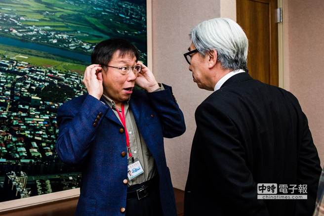 柯在記者采訪前與人交談時露出吃驚的表情。
