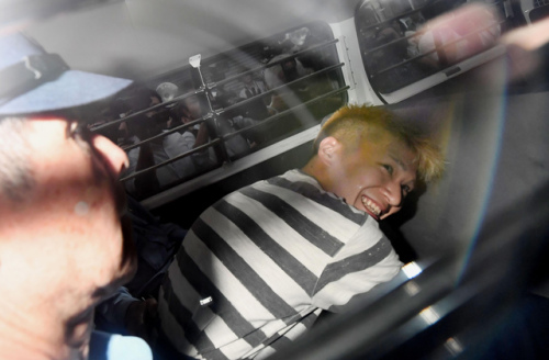　犯罪嫌疑人植松圣在警車里面露微笑。(圖片來源：美聯社)