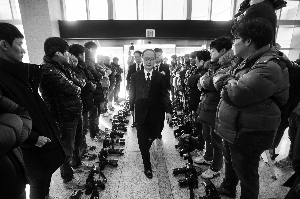 23日，在韓國首爾，日本駐韓大使長嶺安政（中）前往協定簽署現場時，由于協定簽署儀式不對媒體公開，兩旁記者放下相機表示抗議。新華社發