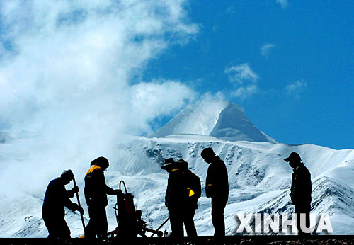 青藏鐵路建設者在西藏桑典康桑雪山腳下整道(2005年6月8日攝)。 青藏鐵路從西寧至拉薩全長1956公里,是世界上海拔最高、線路最長、穿越凍土里程最長的高原鐵路。把鐵路修進西藏是幾代中國人的夢想,但這一想法直到新中國成立后才逐漸變?yōu)楝F(xiàn)實。青藏鐵路一期工程西寧至格爾木段于1958年開工,1984年交付營運。但限于當時國家的經(jīng)濟實力以及高原、凍土等筑路技術(shù)難題尚未解決,格爾木至拉薩段被迫停建。2001年6月,國家總投資330.9億元動工修建青藏鐵路二期工程。這一工程跨越昆侖山、唐古拉山,通過多年凍土層和大片“生命禁區(qū)”,是人類鐵路建設史上亙古未有的穿越。它的建成將為神秘而古老的青藏高原帶來新的生機和活力! 新華社發(fā)